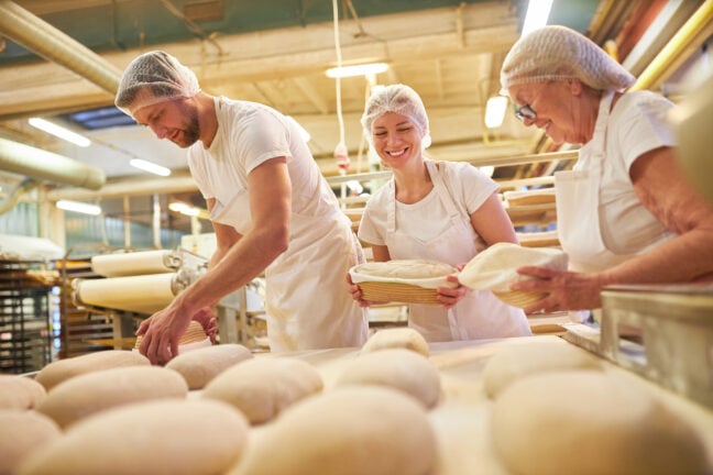 three white individuals in a bakery baking bread