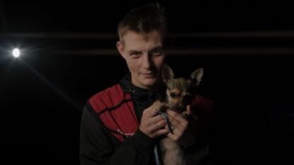 A man experiencing homelessness, supported by St Petrock's holding a dog
