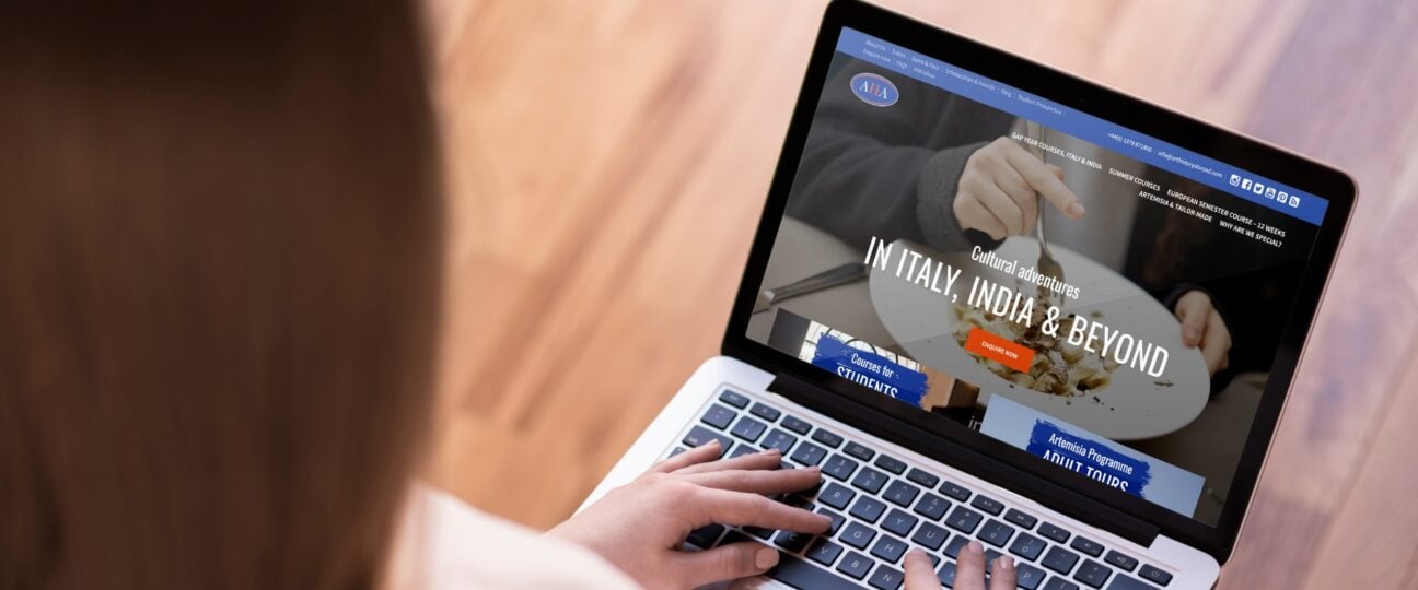 A woman looking at the Art History Abroad website on her laptop